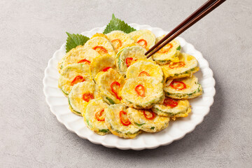 호박전 얇게 썬 애호박에 소금을 조금 뿌려서 두었다가 밀가루를 묻히고 달걀 푼 것을 씌워 부친 전

Pumpkin pancakes: Thinly sliced ​​zucchini sprinkled with a little salt, then coated in flour, covered in beaten egg, and fried.
