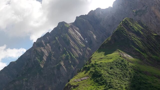 Plan drone 4K des Alpes en plein jour, sommets majestueux sous ciel bleu &eacute;clatant. Paysage naturel spectaculaire, lumi&egrave;re pure, ambiance cin&eacute;matique id&eacute;ale pour voyage, tourisme et outdoor.