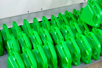 Obraz premium Row of green empty plastic containers standing in a row in a manufacturing plant for packaging liquids