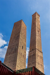 The famous two towers are the symbol of Bologna. The Asinelli Tower (Torre degli Asinelli) is the taller tower on the right, and the Garisenda Tower (Torre Garisenda) is the shorter one.