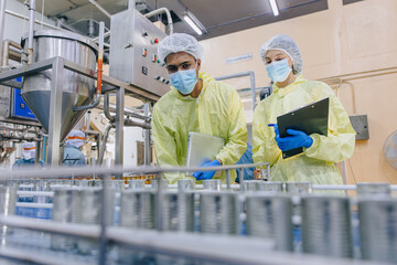 Food hygiene inspector team work examination food production process in line at cannery food factory