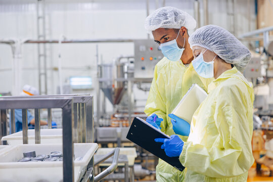 Food hygiene inspector team work examination food production process in line at cannery food factory