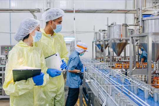 Food hygiene inspector team work examination food production process in line at cannery food factory