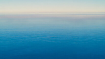 Obraz premium Calm ocean waters at sunrise with gentle ripples