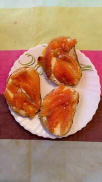 Salmon Sandwiches On White Plate Buttered Buns Topped With Smoked Salmon Slices, Dill Garnish On Linen Tablecloth, Closeup Vibrant Orange Texture, Simple Comfort Brunch.