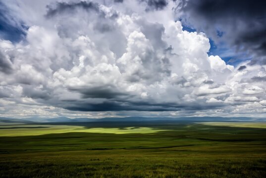 Dramatic storm clouds over vast green landscape with rolling hills