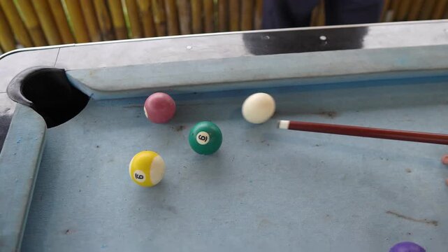 Billiards game action, striking the cue ball to sink a shot in the pocket