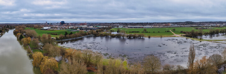 Panoramic view of the River Thames and surrounding flooded land in Reading, Berkshire, showing inundated fields, riverbanks, and waterlogged landscape during high water levels in the UK. © Radd