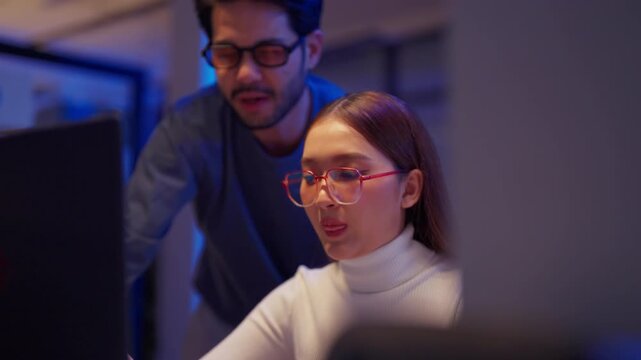 Asian programmers collaborating on software development at night, focused on writing code across multiple monitors in a tech office environment Programmers Collaborating on Software Development	
