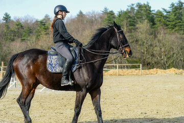 Portrait of a beautiful rider performing cross-walks with her horse