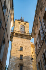 Historic stone clock tower rising above narrow streets in Aix-en-Provence