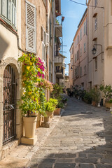 Picturesque Narrow Cobblestone Street with Flowers in Cannes Old Town