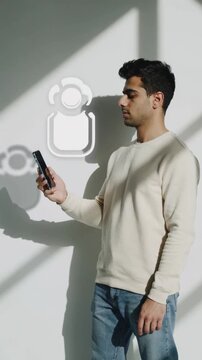 Young Middle Eastern man holding a smartphone as his shadow morphs into an app icon, symbolizing mobile technology, digital interaction, and modern interface design.
