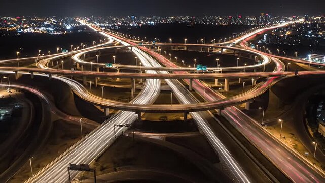 Aerial night view of a complex highway interchange with blurred vehicle trails