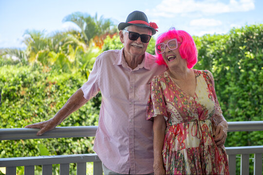 happy senior couple, wearing a fun pink wig and glasses