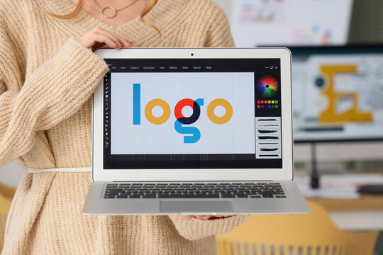 Female web designer with laptop in office, closeup