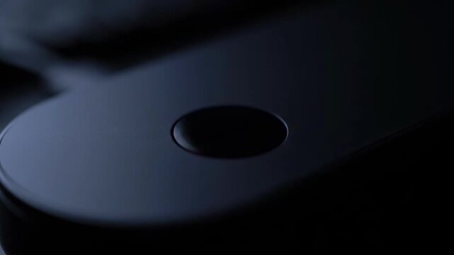 A close-up shot of a sleek, dark-colored game controller focusing on a button. This image evokes a sense of modern gaming and would suit tech reviews 