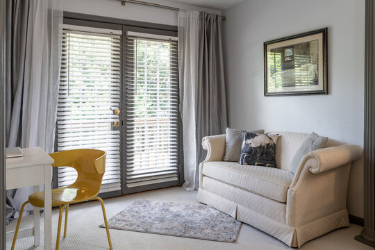 Modern light filled home office or small sitting room with sofa