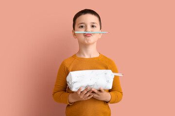 Funny little boy with pencil case on color background © Pixel-Shot