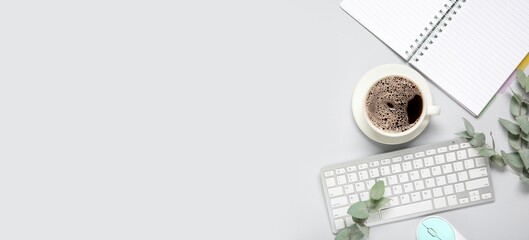 Cup of coffee, computer keyboard, notebook and eucalyptus branches on light background with space for text, top view © Pixel-Shot