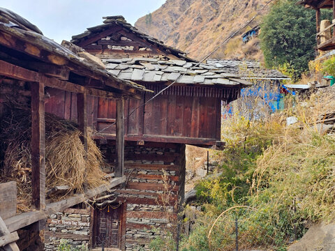 Horizontal Landscape View of Traditional Two-Story Himalayan Stone and Wood House with Slate Roof and Hay Storage in Parvati Valley Himachal Pradesh India.