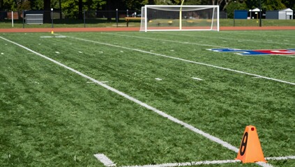 Fototapeta premium View of an American football field with yard lines and a goal post in the distance