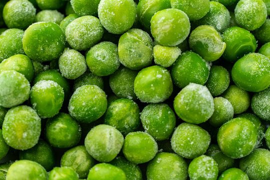 Green peas frozen, close-up, background with legume texture. Freezing and storage of food. Macro photography.