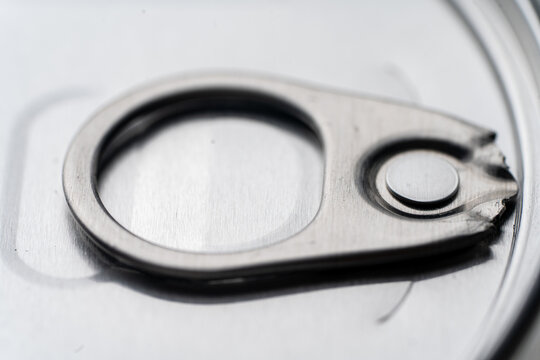 Close-up of a closed metal jar lid with an opening ring, on a white background, perfect for food packaging concepts.