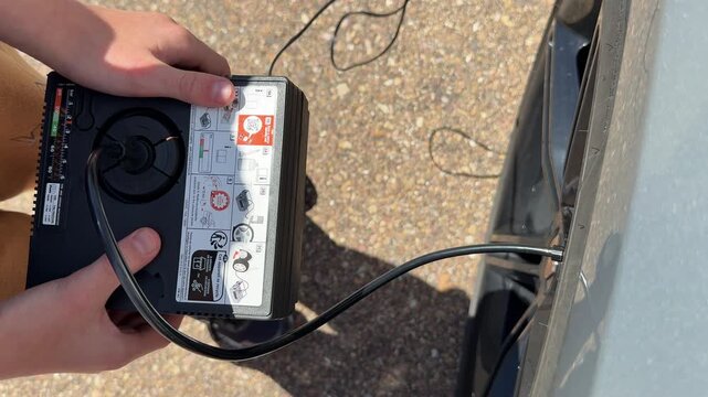 top view: Portable air compressor inflates car tire outdoors