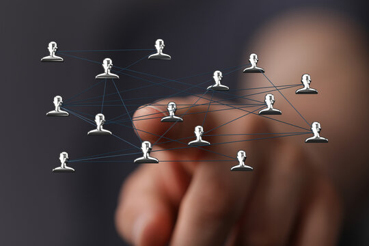 Abstract conceptual image of a human network, connections and communication represented, hand touching the network with finger pointing at a nod