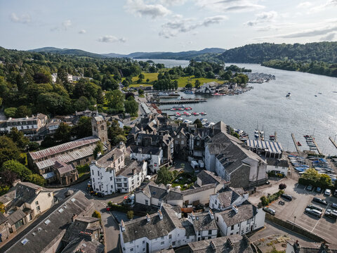 Beautiful aerial view of Windermere with boats, lush greenery, and charming buildings in Cumbria, England during a sunny day