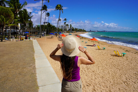 Cheerful traveler woman looking at amazing beach of Maceio, Brazil