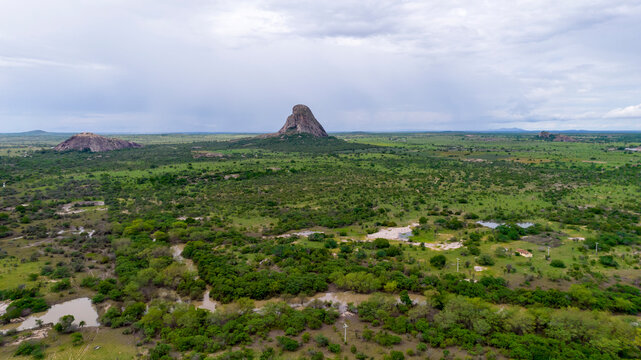 Rock formation in the middle of the green field, aerial view. Stone that Shines, granite rock used by indigenous people of the tribe Tupi-guarani in Brazil, Bahia, Itaberada