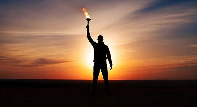 A determined silhouette of a person stands triumphantly holding a blazing torch high against a dramatic, fiery sunset sky.