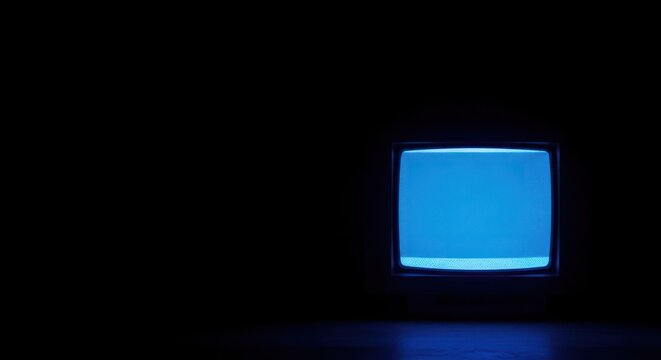 Retro television glowing blue in a dark room