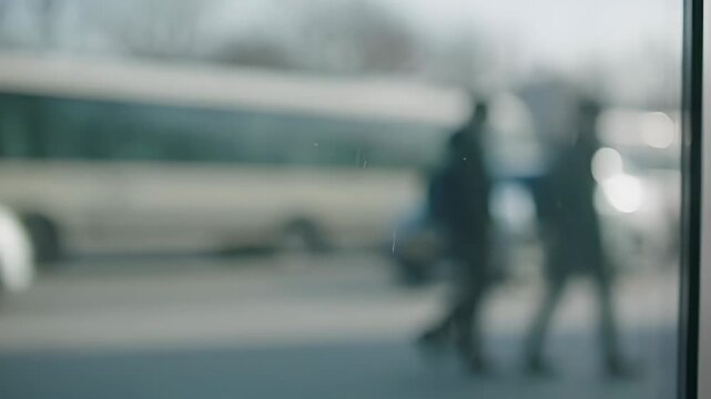 Blurry image of people walking on street with bus in background