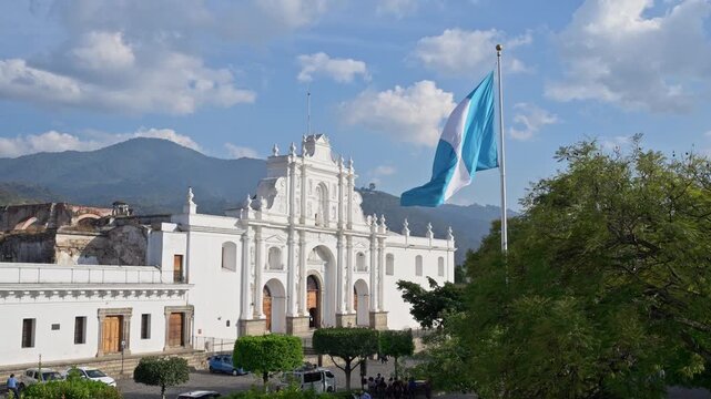 Guatemalan flag waving in front of San Jos&eacute; Cathedral, Parque Central de Antigua Guatemala, Antigua, Guatelmala, Central America