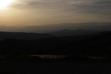 Obraz premium Sunset in El Acebo de San Miguel Overlooking Mountain Landscape July 2024 Golden light above rural valley