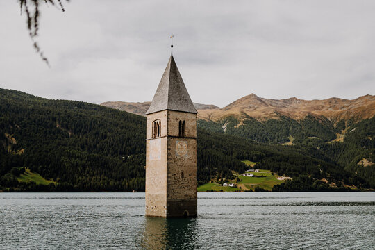Famous half sunken 14th century church bell tower in Lake Reschen (Reschensee) at Curon Venosta, South Tyrol, Italy
