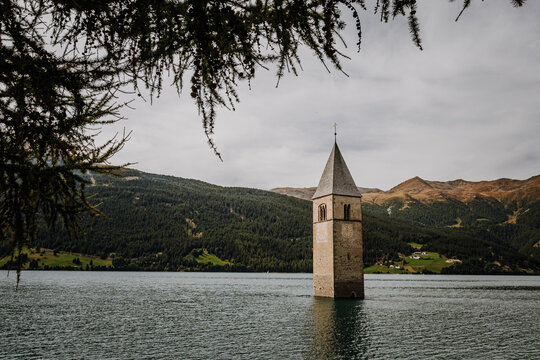Famous half sunken 14th century church bell tower in Lake Reschen (Reschensee) at Curon Venosta, South Tyrol, Italy