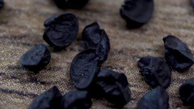 Black wrinkled onion seeds with a matte sheen: Allium cepa. Macro
