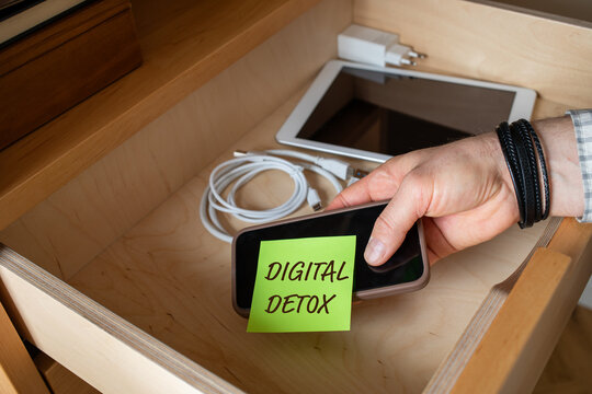 Digital detox with man hand putting phone into drawer. Stop using gadgets, offline from social media and internet, lifestyle balance and mental health concept.
