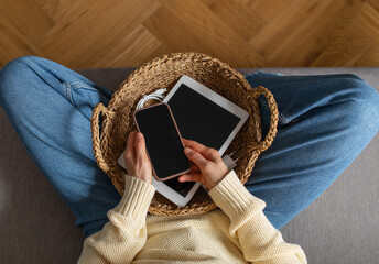 Digital detox from gadgets, social media and internet device addiction with woman on sofa at home putting away phone and tablet in basket for healthy lifestyle balance and mental health.
