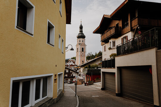Traditional narrow street in Castelrotto (Kastelruth) leading towards the historic parish church tower, South Tyrol