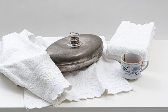 Metallene Bettflasche mit Frottee T&uuml;cher und Tasse Tee