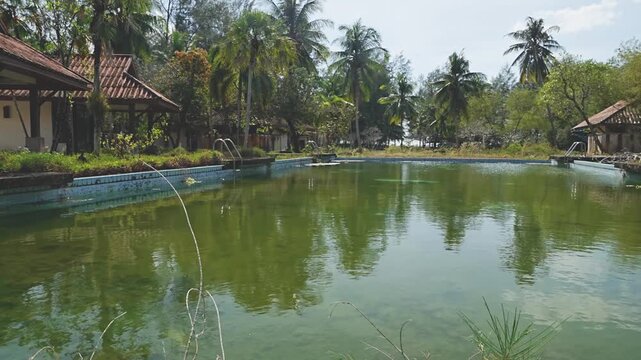 Case study footage: The physical aftermath of a tourism business failure in Thailand, featuring abandoned accommodations and infrastructure being reclaimed by jungle. real time 4k footage