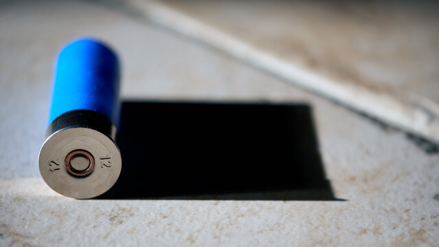 A 12-gauge shotgun shell casts a black shadow