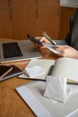 Man at kitchen table checking his savings while planning and managing home budget, financial expenses and calculating unpaid bills for rent and expensive utility payments.