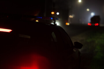 Police Patrol Car with Flashing Emergency Lights at Night on Road © TetianaRUD
