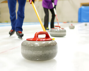 Gra w curling. Zawodnik gra w curling na lodowisku